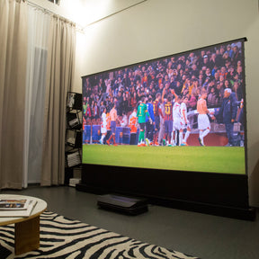 AWOL Vision projector enhances a sports watching experience with a soccer match displayed on a large screen, perfect for gathering with friends.